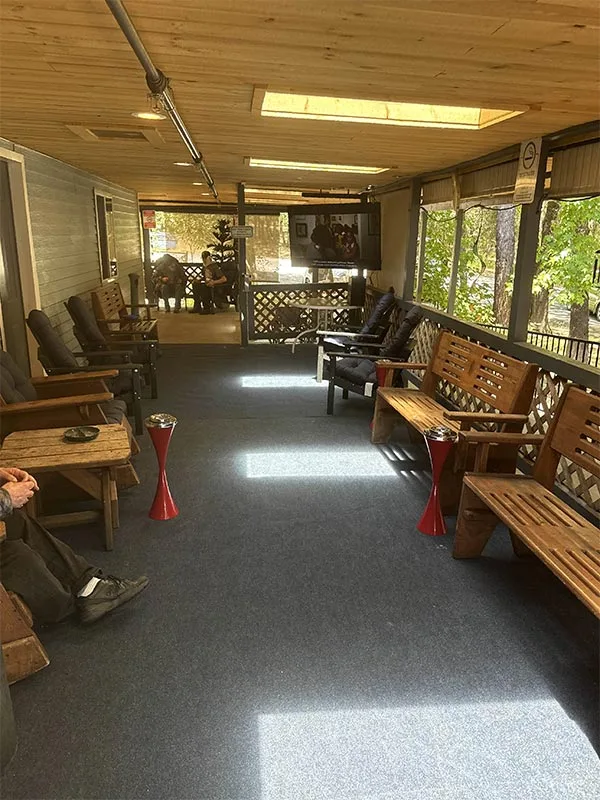 Large, covered wraparound porch with comfortable seating, large flatscreen TV, and skylights to let in light.